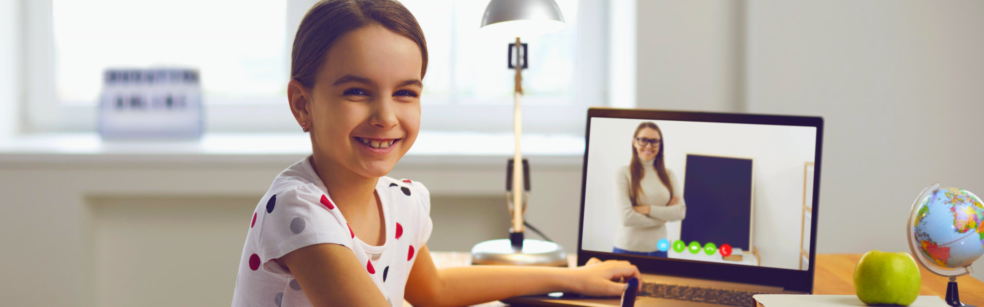 little girl smiling while using laptop